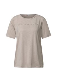 Camiseta de manga corta de color beige claro, de cuello redondo, hecha de tela suave, con un estampado sutil en el frente que dice "puro y seguro".