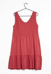 Rotes Baumwollkleid mit V-Ausschnitt, ärmellosem Design und Rüschensaum. Sanfte Textur und lockere Passform. Hängt an einem schwarzen Haken.