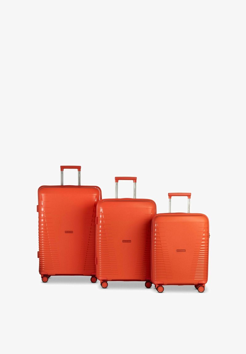 Tre valigie rigide di colore arancione vivace, con un design lineare testurizzato, manici estensibili e quattro ruote per la mobilità.