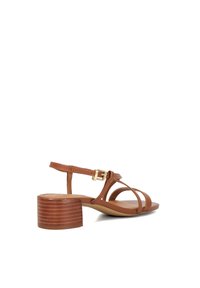 Sandale en cuir marron avec des fines lanières, une fermeture à boucle et un petit talon en bois avec des rainures horizontales.