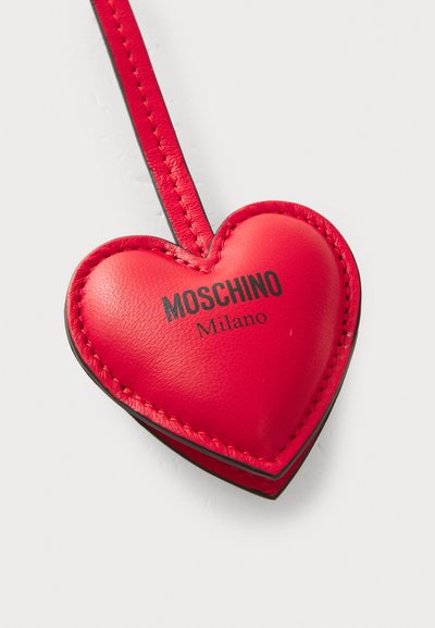 Breloc din piele în formă de inimă roșie, cu margini negre, având textul embosat "Moschino Milano" pe față și o curea asortată.