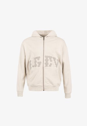 Sudadera beige con cremallera y capucha con cordón, bolsillos frontales y letras texturizadas "LEFT" en gris en el pecho. Textura de tela suave.