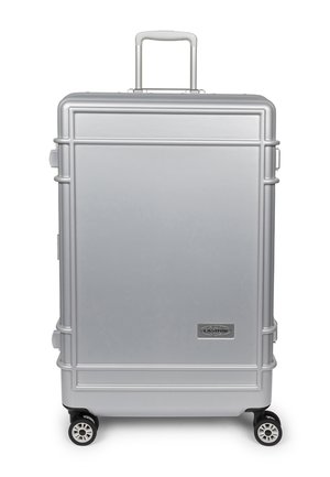 Silver hard-shell suitcase with extendable handle, four spinner wheels, and a small rectangular brand logo on the front lower right corner.