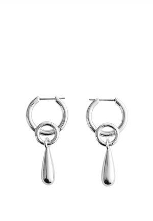 Paire de boucles d’oreilles créoles argentées polies avec un petit anneau circulaire attaché et un pendentif allongé en forme de goutte suspendu en dessous.