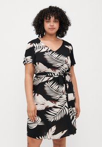 Black dress with short sleeves and a V-neck, featuring a leafy beige and brown print. Includes a matching fabric belt at the waist.