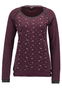 Lila långärmad tröja med blommönster, rund halsringning, kontrasterande svarta detaljer och knappdekorationer på axeln. Mjuk tygkänsla.