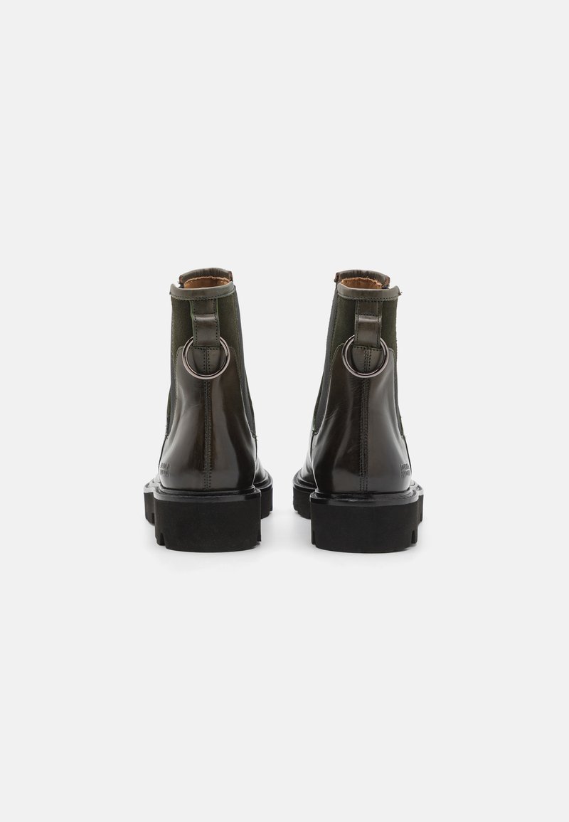 Schwarze Lackleder-Ankle Boots mit grünen Textilakzenten, silbernen Ringbeschlägen und einer klobigen schwarzen Sohle. Die Rückansicht zeigt ein gestepptes Design.