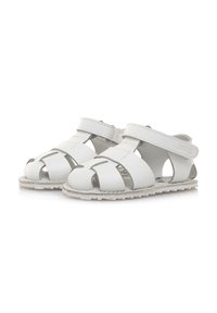 Sandalias de cuero blancas con un diseño de tiras entrelazadas, lados abiertos y cierre de velcro, que cuentan con una suela de goma texturizada para mayor tracción.
