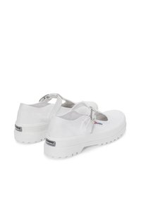Scarpe Mary Jane bianche in tela con punta tonda, cinturino regolabile e suola in gomma bianca con un motivo di battistrada testurizzato.