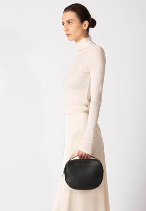 Borsa a mano in pelle nera dalla forma arrotondata, con una texture liscia e un manico. Il design presenta una chiusura con cerniera e dettagli di cuciture sottili.