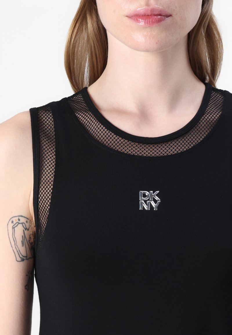 Top negro sin mangas con un escote de malla, que presenta un logo plateado de DKNY. La tela es suave, con un diseño ajustado y un estiramiento moderado.