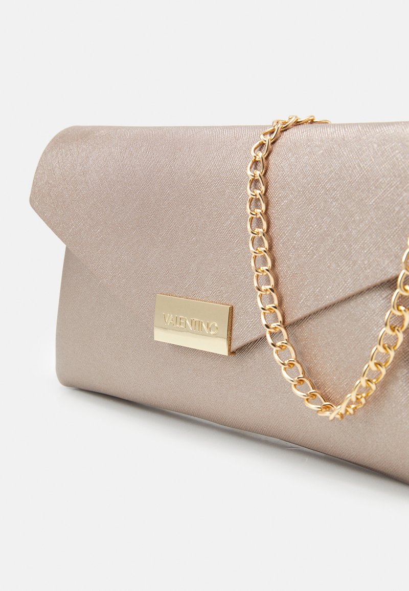 Metallisch taupefarbene Clutch mit Umschlagdesign, ausgestattet mit einem goldenen Kettenriemen und einer goldenen Logo-Platte. Strukturierte Stoffoberfläche.