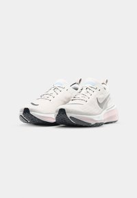 White athletic shoes with a textured upper, grey accents, a pink midsole, and black rubber outsole. Includes a padded collar and laces.