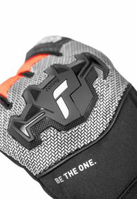 Black and gray motorcycle glove with textured geometric patterns, rubber armor, and bright orange accents. "BE THE ONE" printed on the wrist.