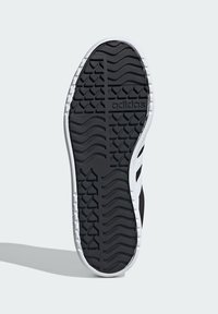 Czarna guma podeszwy zewnętrznej z teksturowanym wzorem antypoślizgowym i białymi akcentami, z logo Adidas. Smukły kształt z zaokrąglonym noskiem.