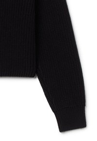 Schwarzer, gerippter Strickpullover mit Ärmel, der ein strukturiertes Material, einen enganliegenden Bund und eine leicht lockere Passform in der Nähe der Schulternaht aufweist.