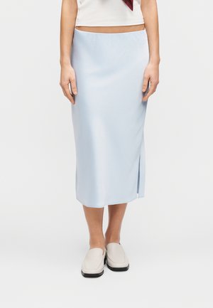 Hele sinine satiinist midi-seelik küljetagavolt lõhikuga, sileda tekstuuri ja minimalistliku disainiga, kombineeritud valgete loafers-sussidega.