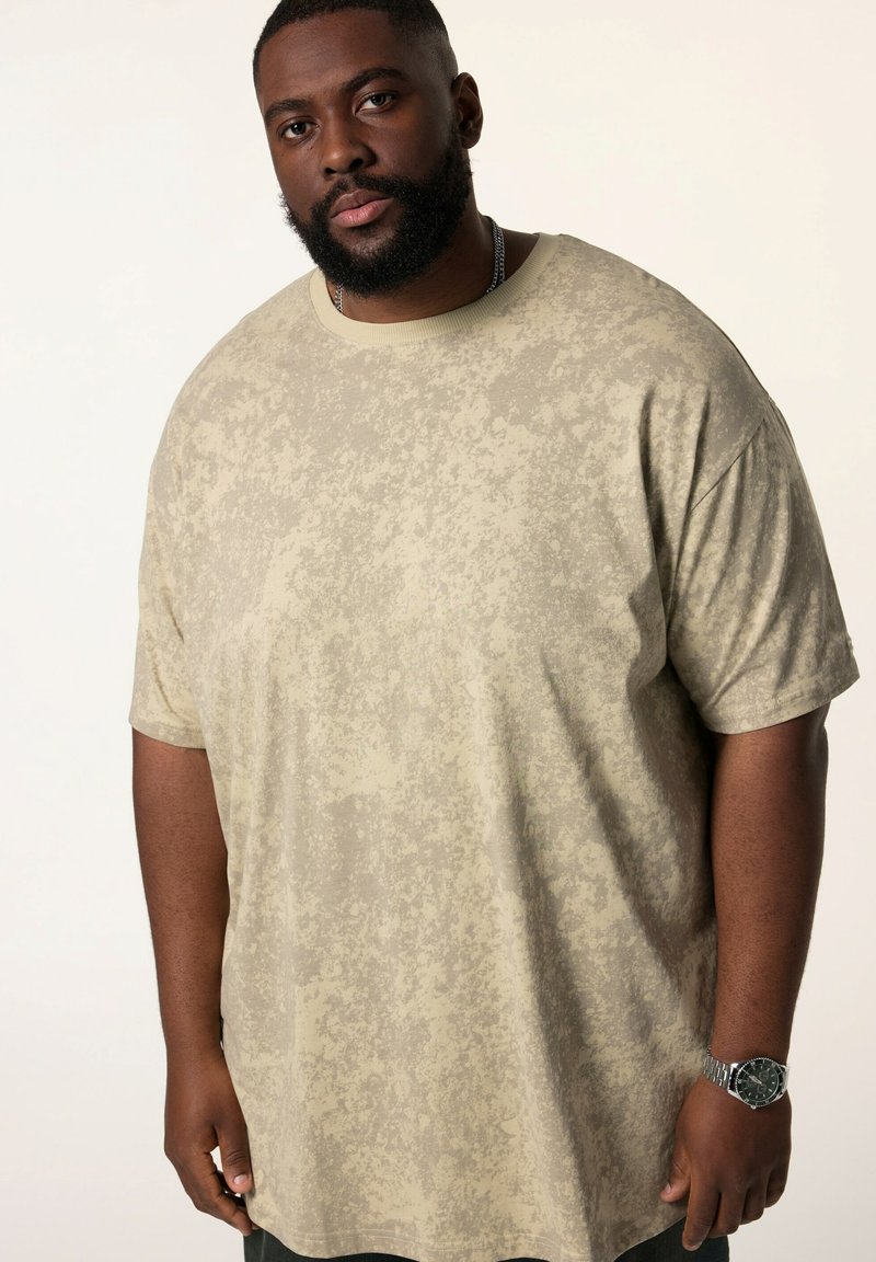 Beige kortærmet t-shirt med et struktureret mønster. Løs pasform med en rund halsudskæring. Stoffet føles blødt og let.