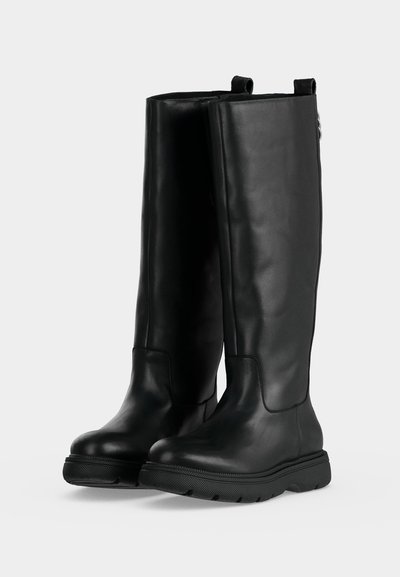 Paire de bottes en cuir noir montantes jusqu'aux genoux avec semelles épaisses en caoutchouc texturé et languettes de tirage en haut.