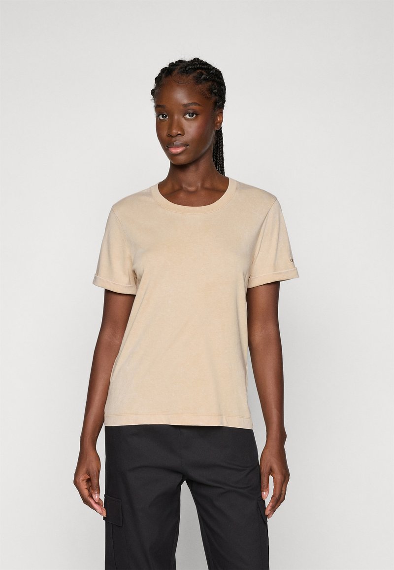 Beige Baumwoll-T-Shirt mit rundem Halsausschnitt, kurzen Ärmeln und umgeschlagenen Ärmeln, im lockeren Schnitt und mit subtiler Textur.