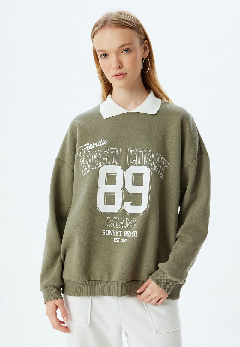 Sudadera verde oliva con cuello blanco y texto impreso. Cuello redondo, mangas largas, puños acanalados, con gráficos de "89" y "Florida WEST COAST".