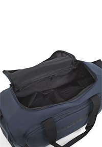 Bolsa de deporte de navy con un amplio interior negro, asas de tela dobles y una abertura superior con cremallera. Logotipo mostrado en el lateral.