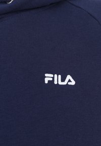 Felpa blu navy in morbido cotone con texture a coste; presenta un logo Fila ricamato in bianco sul petto.