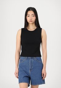 Black sleeveless top made of smooth fabric, paired with high-waisted blue denim shorts featuring a classic five-pocket design and cuffed hem.