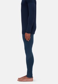 Marineblaues Langarmshirt und dunkelblaue Leggings; glatte Textur. Die Leggings verfügen über ein feines Zickzackmuster, eine figurbetonte Silhouette und Beinabschlüsse.