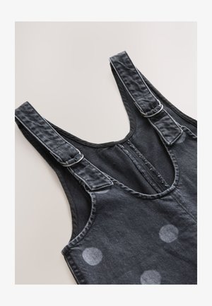 Fekete farmer overall állítható pántokkal, elülső cipzárral és fehér pöttyös mintával. Puha tapintású és tiszta varrásokkal.