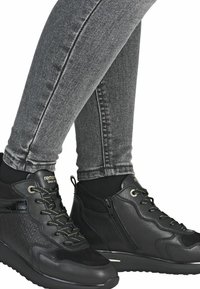 Černé sneakers do kotníků s texturovanými černými akcenty, šněrovacím designem a bočním zipem. Vybaveny pohodlnou cushioned podrážkou.