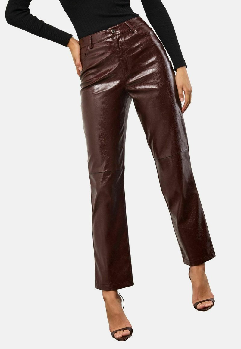 Browni mākslīgās ādas platās kājas bikses ar spīdīgu apdari, ar priekšējo pogu aizdari un jostas cilpiņām. Viegla tekstūra un piegriezuma pielāgojums.