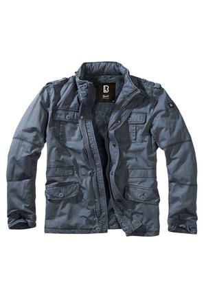 Chaqueta gris masculina, con cierre de cremallera y botón, cuatro bolsillos frontales, forro interior suave y tejido ligeramente texturizado.