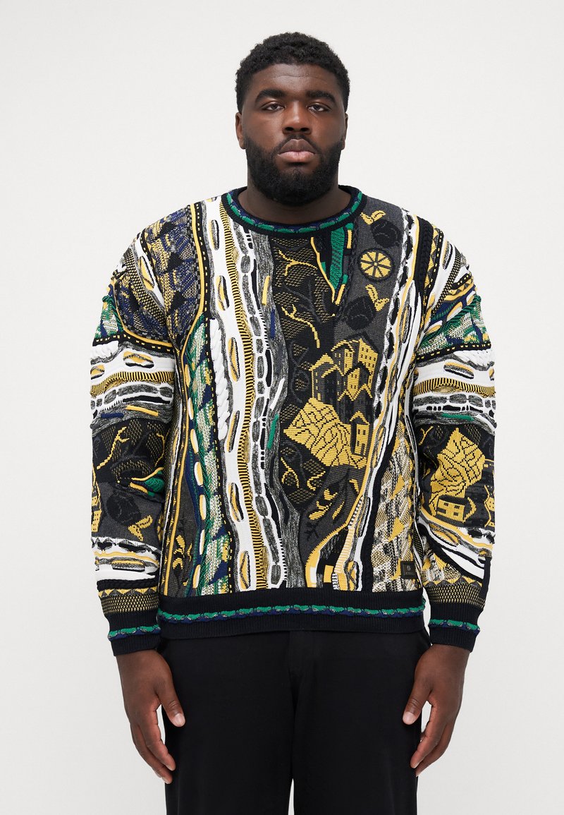 Pull en tricot avec un motif géométrique multicolore et des accents noir, blanc, vert et or. Col et poignets côtelés, design texturé.