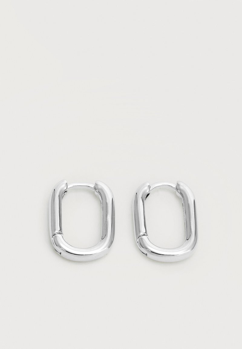 Ζευγάρι γυαλιστερά ασημένια ορθογώνια σκουλαρίκια με στρογγυλεμένες γωνίες σε λευκό φόντο.