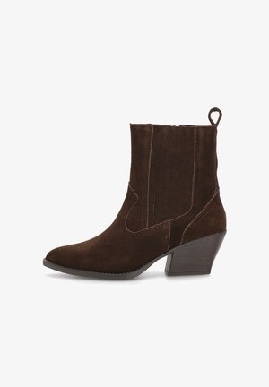 Botín de ante marrón con punta afilada y tacón cuadrado. Presenta paneles elásticos laterales y una pequeña pestaña en la parte posterior.