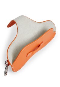 Πορτοφόλι από πορτοκαλί δέρμα με σουέντ εσωτερικό, καμπυλωτές άκρες και λευκή ραφή. Διαθέτει μικρή λαβή και μεταλλικό γάντζο για προσάρτηση.