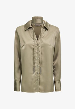 Chemise en satin vert olive à manches longues, col évasé, fermeture à boutons sur le devant et deux fronces au niveau du col. Texture lisse.