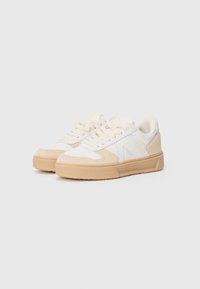 Hvite sneakers med beige aksenter, med en glatt skinnoverdel, snøring, polstret tunge og teksturert gummisåle.