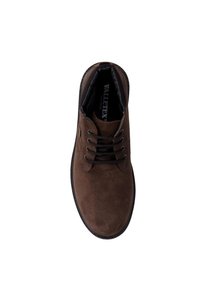 Scarpa in suede marrone con punta rotonda, design con lacci neri e superficie texture. Presenta un logo sulla soletta e dettagli di cucitura in evidenza.