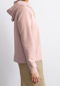 Felpa con cappuccio rosa realizzata in un materiale morbido. Presenta maniche lunghe, polsini a costine e una vestibilità comoda. Il design non ha motivi né dettagli.