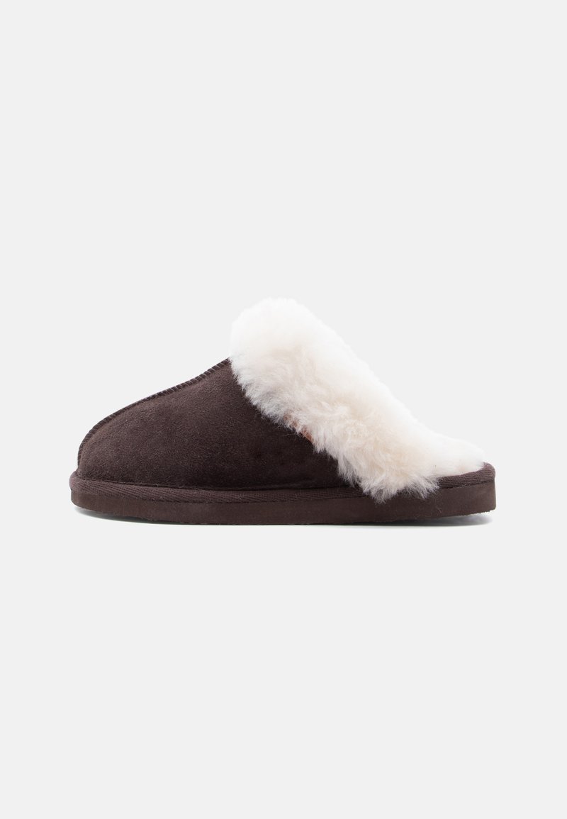 Chausson marron en daim à enfiler avec une épaisse doublure blanche et moelleuse autour de l'ouverture et une semelle plate.