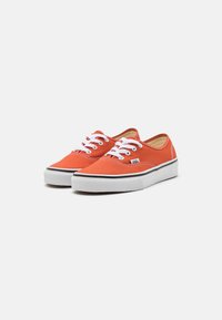 Sneakers di tela arancione con lacci bianchi, suola in gomma nera e dettagli di cucitura a contrasto. Design low-top per un look casual.