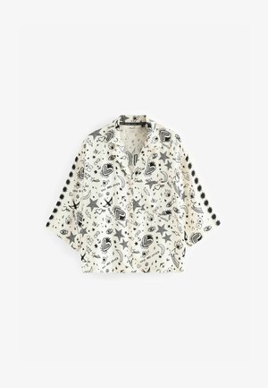 Krátký rukáv košile z bílé látky s černými doodlovými vzory srdcí, hvězd, očí a textu. Volný střih s límečkem.