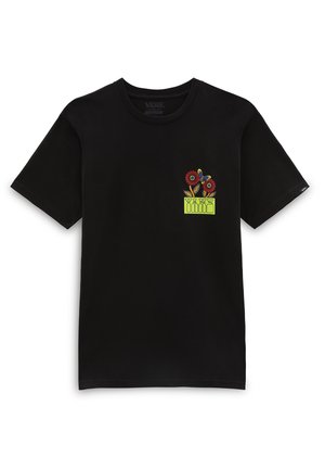 T-shirt Vans noir à manches courtes avec un petit motif coloré de fleurs rouges et un papillon au-dessus d’un design rectangulaire vert sur la poitrine gauche.