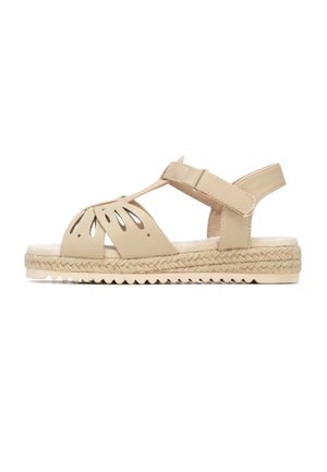 Sandalia beige con diseño floral recortado, correa ajustable en el tobillo y suela de yute trenzado. Plantilla texturizada y suela de goma para mejor agarre.