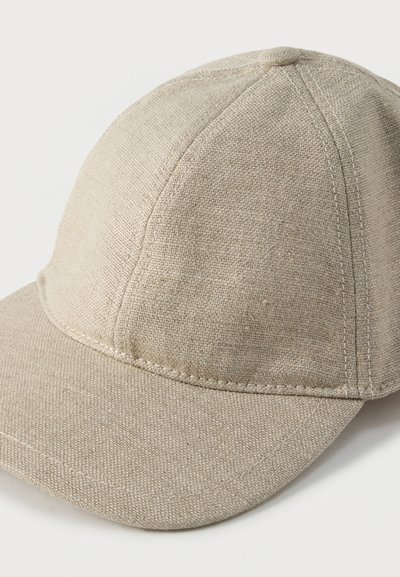 Μπεζ υφασμάτινο καπέλο με δομημένη κορυφή, επίπεδη γείσο και ορατές ραφές. Το υλικό έχει υφή πλεκτού με ανάγλυφη εμφάνιση.