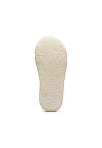 Suela de un calzado, goma de color crema con un diseño de relieve que presenta un logotipo y círculos, textura suave, forma redondeada.