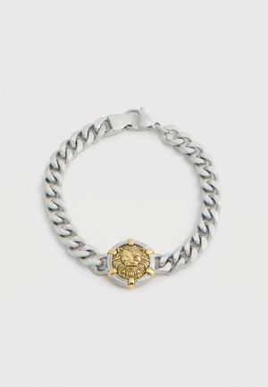 Bracciale a catena in argento con un centro di testa di leone dorato fissato da artigli d'oro e una chiusura a moschettone incisa con la scritta "GUESS".