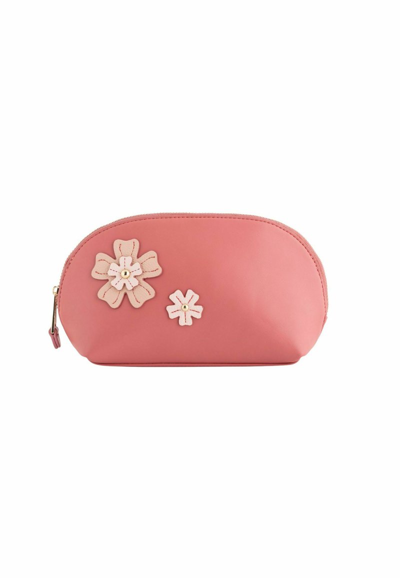 Bolso de maquillaje de cuero rosa con forma redondeada, adornado con dos flores crema y un cierre de cremallera dorada.